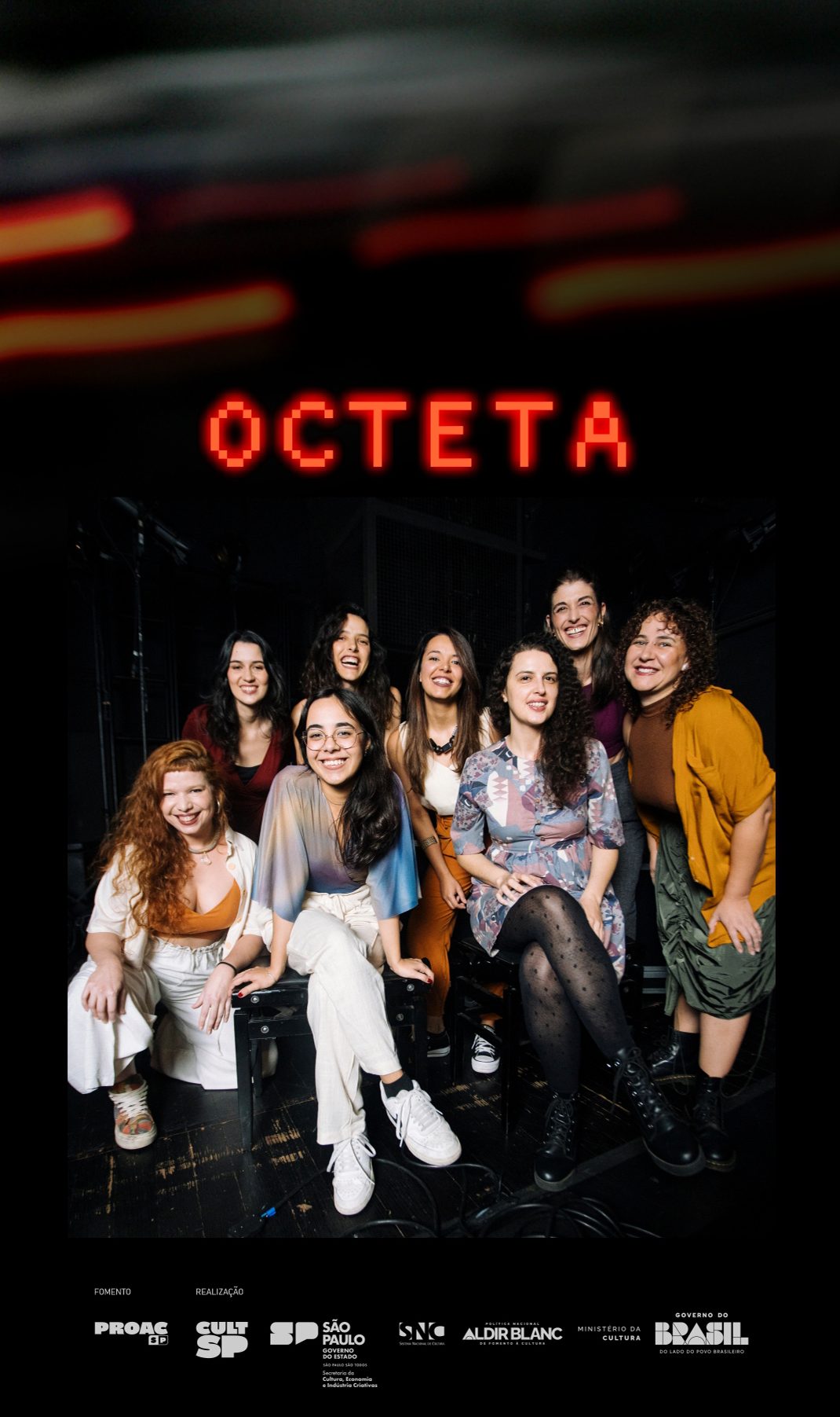 Banner vertical com o nome OCTETA em vermelho sobre fundo escuro com feixes de luz laranja. Abaixo, foto institucional do grupo musical Octeta, com oito mulheres sentadas e em pé em um palco. Todas têm pele clara e cabelos escuros, usam roupas casuais coloridas. Logo abaixo, sobre fundo preto, logotipos brancos de fomento e realização, como ProAC, CultSP, Governo do Estado de São Paulo, SNC, Política Nacional Aldir Blanc de fomento à cultura, Ministério da Cultura, Governo do Brasil.